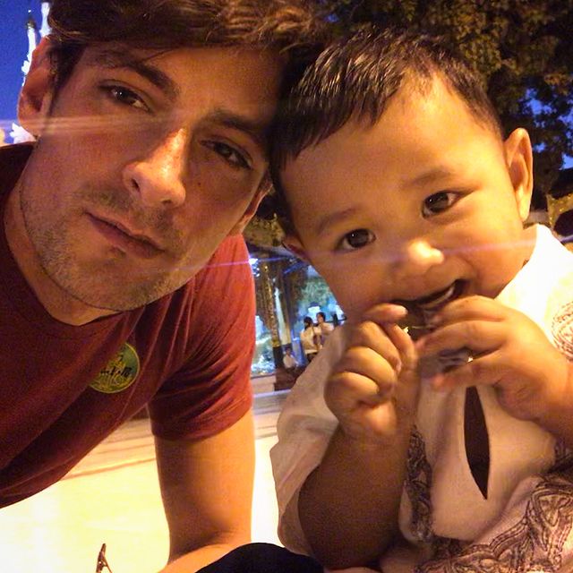 Brice Bexter in a red t-shirt with a kid in a white dress.